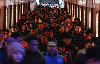 "Compramos el billete con hasta 20 días de antelación (...) Sólo podemos ver a mi hijo en el Año Nuevo chino", explicó Oin Yuzhen, empleada de una fábrica de 42 años sentada al sol a las puertas de la estación de tren central de Pekín. En la imagen, los pasajeros se dirigen a los andenes para esperar su tren en Pekín (China).