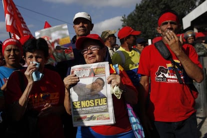 Una mujer sujeta un periódico con un retrato de Hugo Chávez durante el traslado del féretro del presidente venezolano a la Academia Militar donde tendrá lugar las honras fúnebres por el que ha sido jefe del Estado durante 14 años.