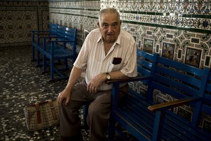 Macario García Consuegra, maquinista jubilado, en la sala de espera de Alcázar de San Juan, decorada con azulejos alusivos al Quijote.