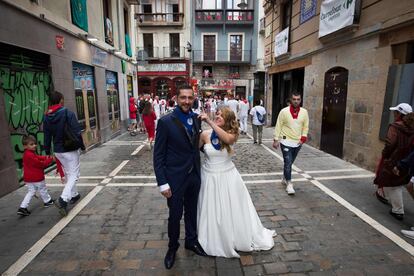 Una pareja de recién casados pasea por las calles tras la tercera corrida de los Sanfermines 2019, en Pamplona.