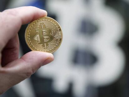  Una moneda de bitcoin sobre el s&iacute;mbolo de la criptodivisa.