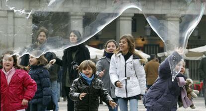 Niños jugando, a pesar de las bajas temperaturas, en la plaza Mayor de Madrid.