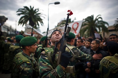 Un soldado sostiene su fusil, con una flora en el cañón, durante una protesta en Túnez.