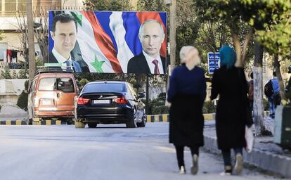 Una pareja de mujeres sirias pasa por delante de un cartel del presidente sirio Bashar al-Assad (izquierda) y su homólogo ruso, Vladimir Putin (derecha), en el norte de la ciudad de Alepo (Siria).
Alrededor de 312.000 personas han muerto y millones han huido desde que comenzó la revuelta contra el presidente sirio, hace ya seis años.