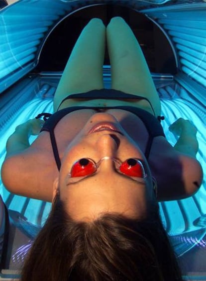 Una mujer se broncea en una cabina de rayos UVA.