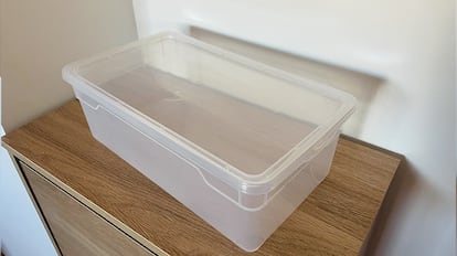 Cajas de plástico para almacenamiento sobre una mesa de madera.