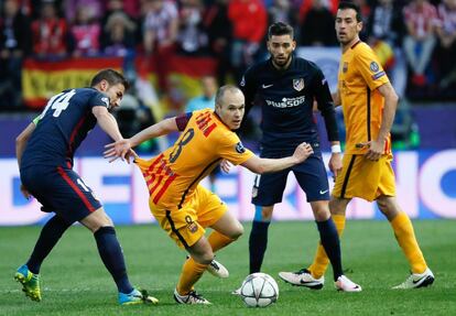 El centrocampista del FC Barcelona Andrés Iniesta (2i) se escapa de Gabi Fernández (i), del Atlético de Madrid.