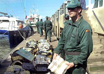 Agentes de la Guardia Civil, junto al alijo y el barco intervenidos en Mazagón.
