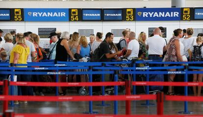 Decenas de viajeros hacen cola, esta mañana en el aeropuerto de Alicante, en los mostradores de embarque de la compañía Ryanair, afectada por la huelga de sus pilotos en varios países. 