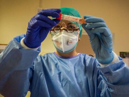 Un trabajador sanitario inspecciona una muestra de un paciente con coronavirus en Cremona (Italia)