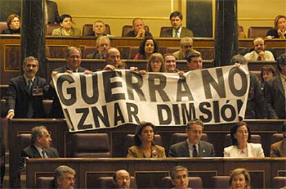 Los diputados de Izquierda Unida despliegan una pancarta de "no a la guerra" al inicio del debate parlamentario.