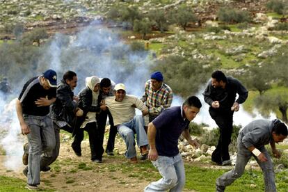 Aunque menos intensa que en semanas anteriores, la reunión entre Abbas y Sharon no ha acabado con la violencia en Oriente Próximo. En la imagen un grupo de palestinos que protestaban contra el muro que construye Israel se enfrentan a los soldados cerca de Ramala.