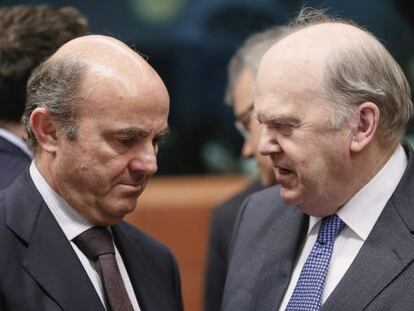 El ministro irland&eacute;s de Finanzas, Michael Noonan, conversa con el espa&ntilde;ol Luis de Guindos, durante el Eurogrupo celebrado este lunes.