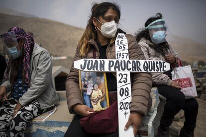 Ruth Morales, de 36 años, en el centro, espera la llegada del ataúd de su esposo, Juan Paucar Quispe, de 63, quien murió por complicaciones por la covid-19, durante su entierro en el cementerio de Carabayllo. Las muertes por covid-19 se aproximan a las 28.000. Sin embargo, los registros de defunciones revelan que los decesos durante la pandemia se han incrementado en un 120% respecto al mismo periodo de años anteriores y existe un exceso de unas 65.000 muertes.