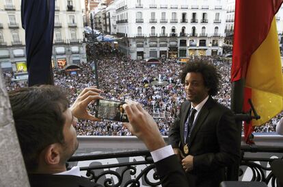 El capit&aacute;n del Real Madrid Iker Casilla fotograf&iacute;a a su compa&ntilde;ero de equipo Marcelo en el balc&oacute;n de la sede de la Comunidad de Madrid en la Puerta del Sol.