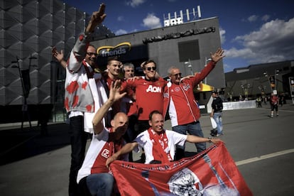 Un grupo de seguidores del Ajax y del Manchester posan en el exterior del estadio.