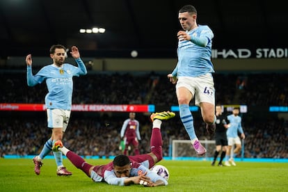 Phil Foden, del City, salta junto a Diego Carlos el miércoles pasado durante el City-Aston Villa de Premier.