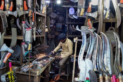 Un trabajador de Bangladés afila un cuchillo en su tienda.