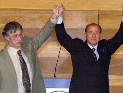 El magnate y candidato de la derecha, Silvio Berlusconi, levanta la mano de su socio de coalición, Umberto Bossi, ayer en Milán.