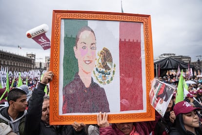 Un hombre muestra un cuadro con la imagen de Claudia Sheinbaum. 