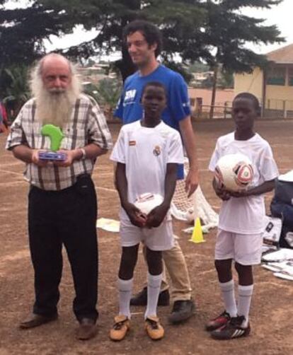 El padre Natalino con dos jóvenes equipados con uniformes del Real Madrid enviados por la fundación del club.