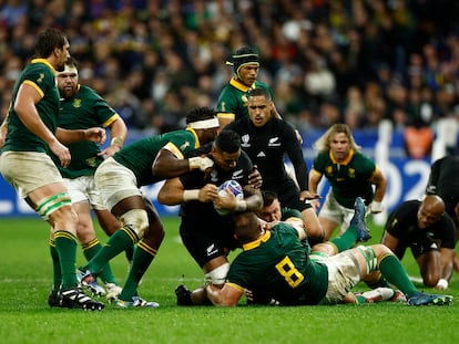 Jugadores de Nueva Zelanda y Sudáfrica se disputan el balón durante la final del mundial de rugby.