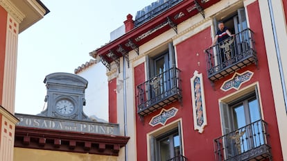 Un turista se asoma a uno de los balcones de la antigua Posada del Peine (hoy es el Petit Palace Hotel), en el centro de Madrid, el pasado julio.