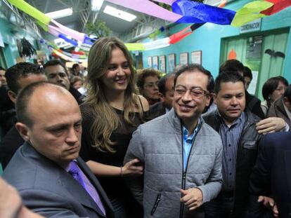 El nuevo alcalde de Bogotá, Gustavo Petro, junto a su mujer (a la izquierda de la imagen) en el centro electoral.