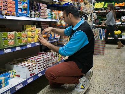 Un franquiciado coloca los productos en las estanter&iacute;as de un supermercado de Sants.