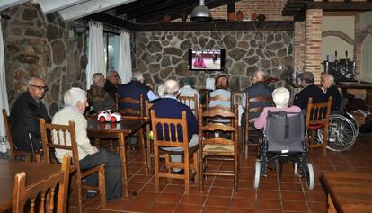 Un grupo de ancianos ven la televisión en una residencia