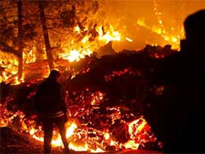 Bomberos vigilan los incendios ocasionados por la lava del volcán.