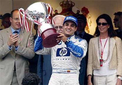 Juan Pablo Montoya levanta su trofeo de ganador ante la familia principesca de Mónaco: Alberto, Raniero y Carolina.