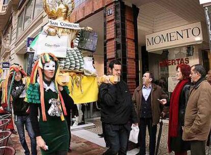 Ciudadanos sorprendidos en el centro de Valencia por la procesión de la ONG Setem contra el consumismo.