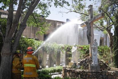 Los bomberos trabajan en la extinción del incendio de la misión de San Gabriel, este sábado.