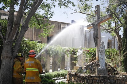 Los bomberos trabajan en la extinción del incendio de la misión de San Gabriel, este sábado.