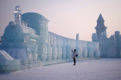Un hombre visita las esculturas de hielo del Festival Internacional de Esculturas de Hielo y Nieve que se celebra Harbin, ciudad del norte de China, el pasado día 4.