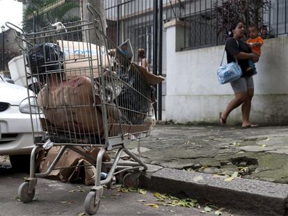 Una mujer y un niño pasan ante un cadáver metido en un carro de la compra, el pasado martes en la favela Morro dos Macacos.