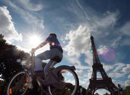 Un cicloturista pedalea por los alrededores de la torre Eiffel.
