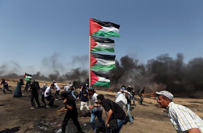 Un manifestante sostiene unas banderas palestinas durante el ataque israelí en la Franja de Gaza.