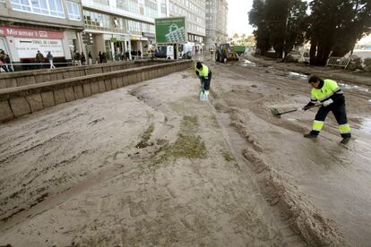 <b>La playa de Riazor.</b> Una de las zonas más afectadas por el azote de la ciclogénesis en la ciudad de A Coruña ha sido la de la playa de Riazor. En la imagen, dos operarios trabajan para despejar un tramo del paseo marítimo.