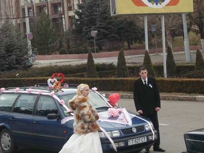 Una pareja de recién casados, en el centro de Tiráspol, frente al escudo de los independentistas.