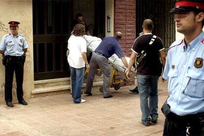 Miembros de los servicios funerarios transportan el cadáver de una de las dos mujeres encontradas muertas en un piso de L'Hospitalet.