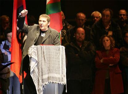 El acto por el que el juez ha ordenado volver a sentar en el banquillo a Arnaldo Otegi se celebró el 14 de noviembre de 2004 en el velódromo de Anoeta y fue tolerado por las autoridades. En la imagen, el líder de Batasuna extiende sobre el atril un pañuelo palestino, en memoria de Arafat.