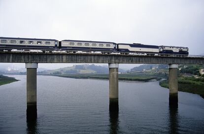 El tren Transcantábrico, a su paso por la ría de Navia, en Asturias.