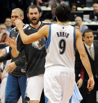 Ricky Rubio se acerca a chocar la mano con Kevin Love.