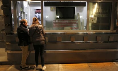 Two moviegoers at the box office of a Madrid cinema.