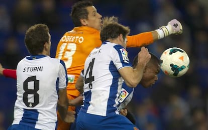 Roberto trata de despejar ante tres rivales.