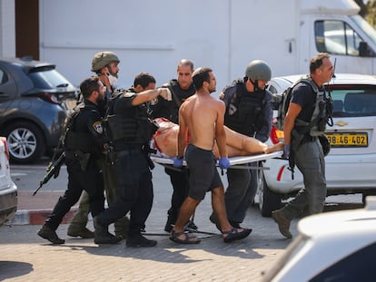 Miembros de las fuerzas de seguridad israelíes trasladaban este sábado a una mujer herida por un cohete lanzado desde Gaza sobre Ashkelón.