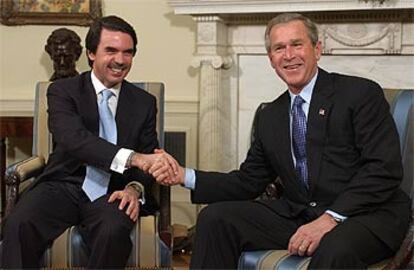 José María Aznar y George Bush se dan la mano durante la entrevista que mantuvieron en el Despacho Oval.