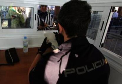 Un policia nacional verifica la identidad de una ciudadana marroquí en el puesto fronterizo entre España y Marruecos.